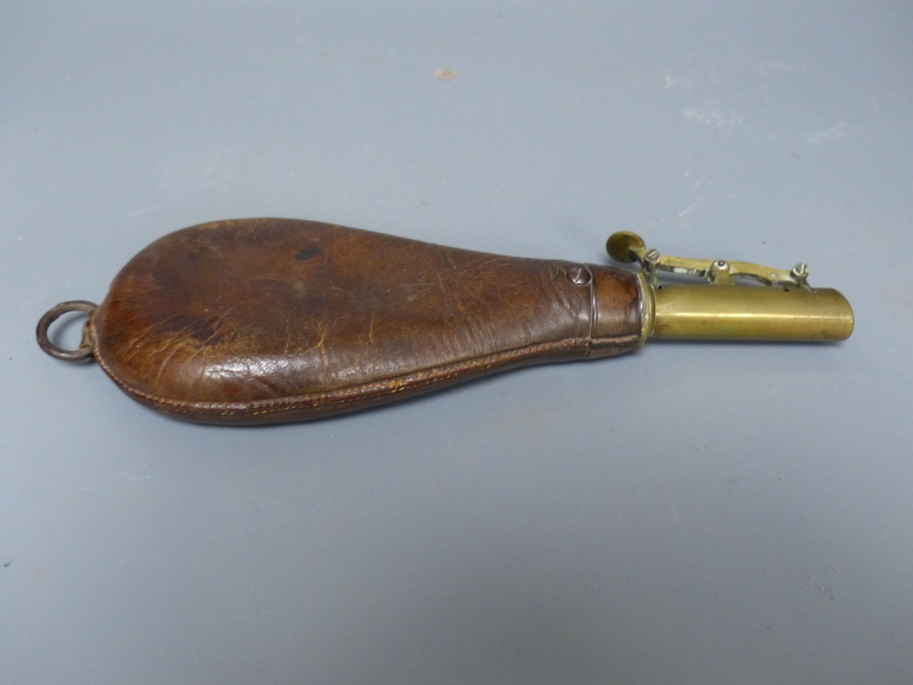 A 19th century brown leather and brass powder flask, overall length 23cm